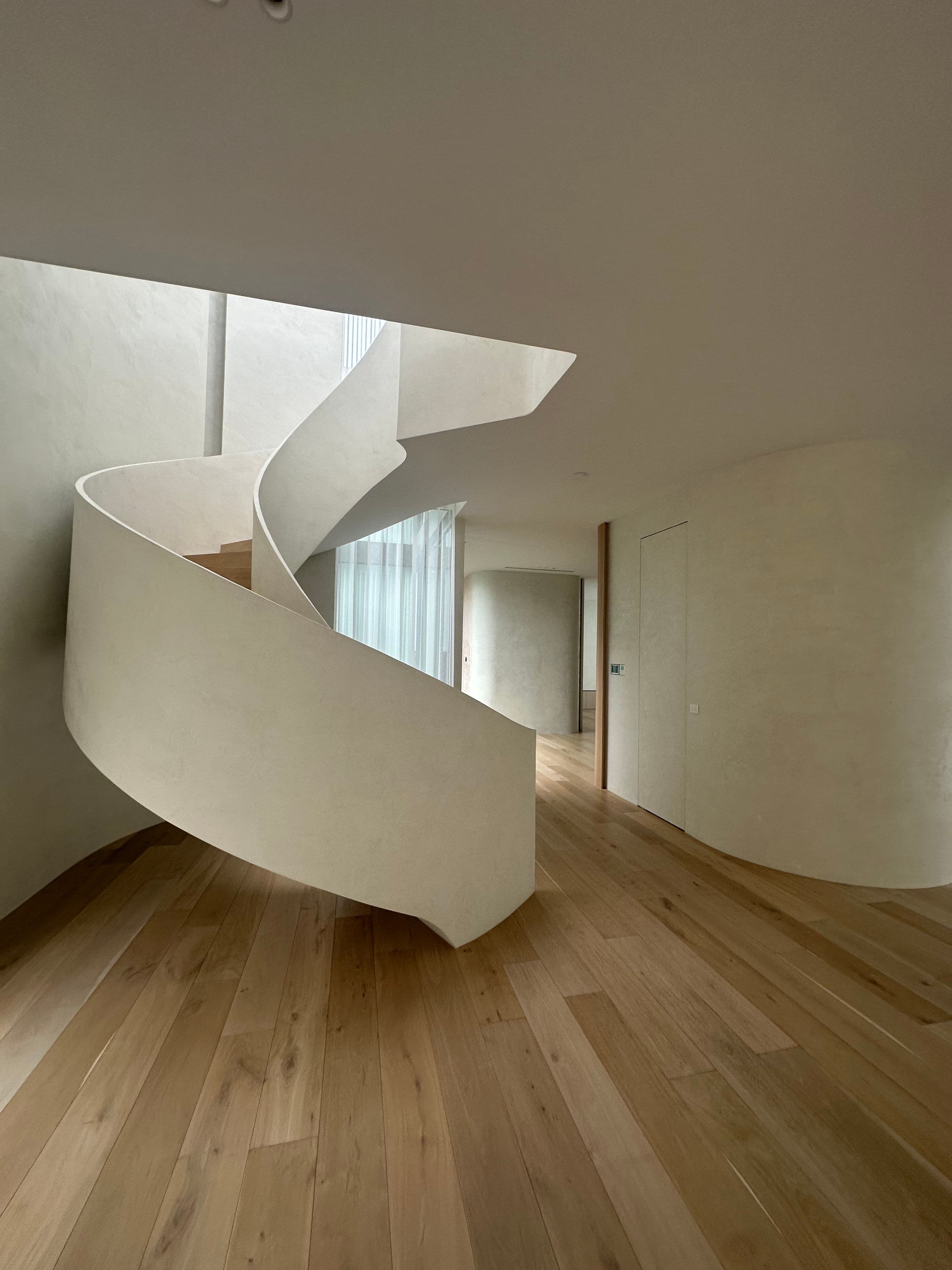 Cashmere oak flooring and matching timber treads on a curved staircase in Kew.