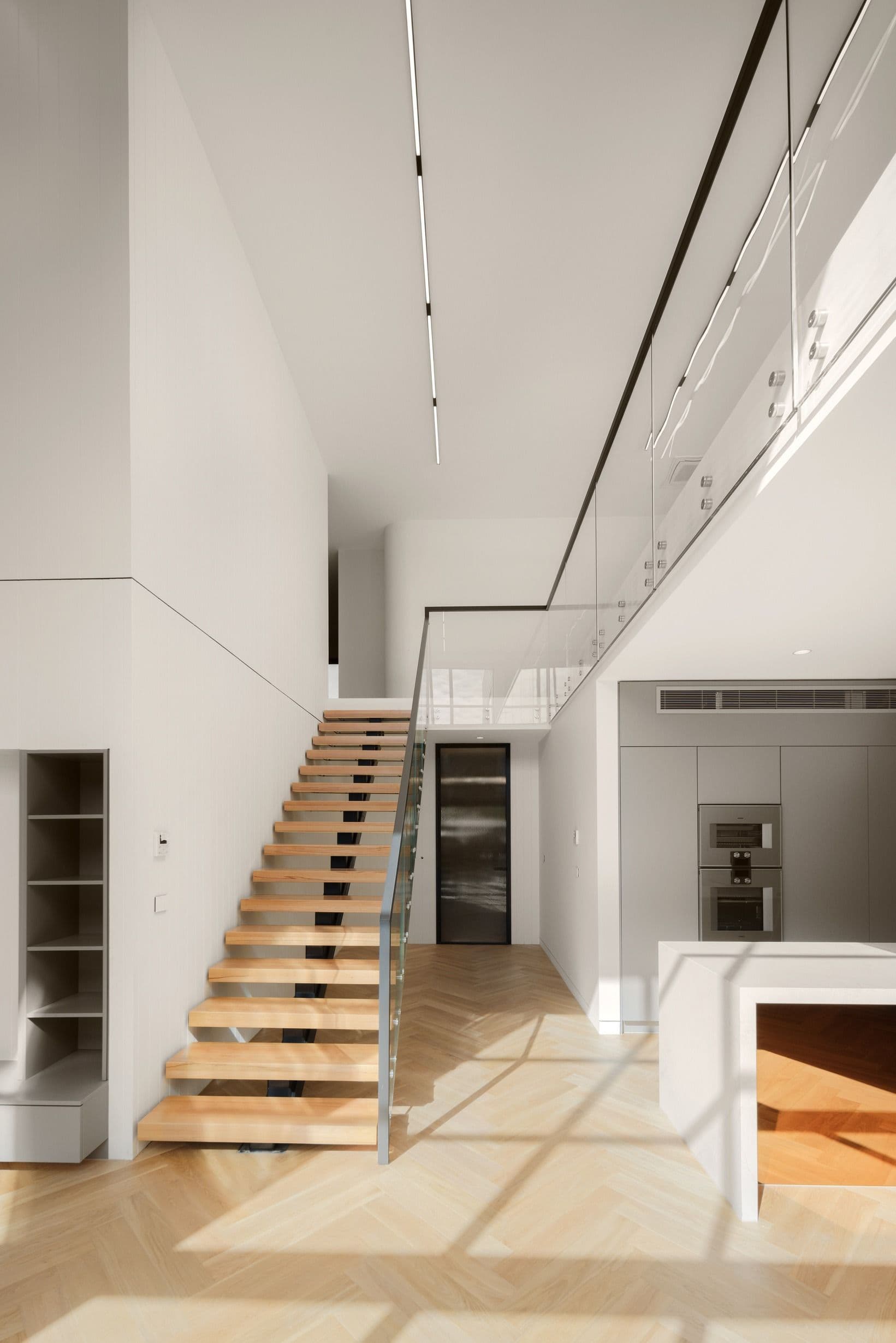 Natural Oak herringbone flooring through a double-height Kew living space.