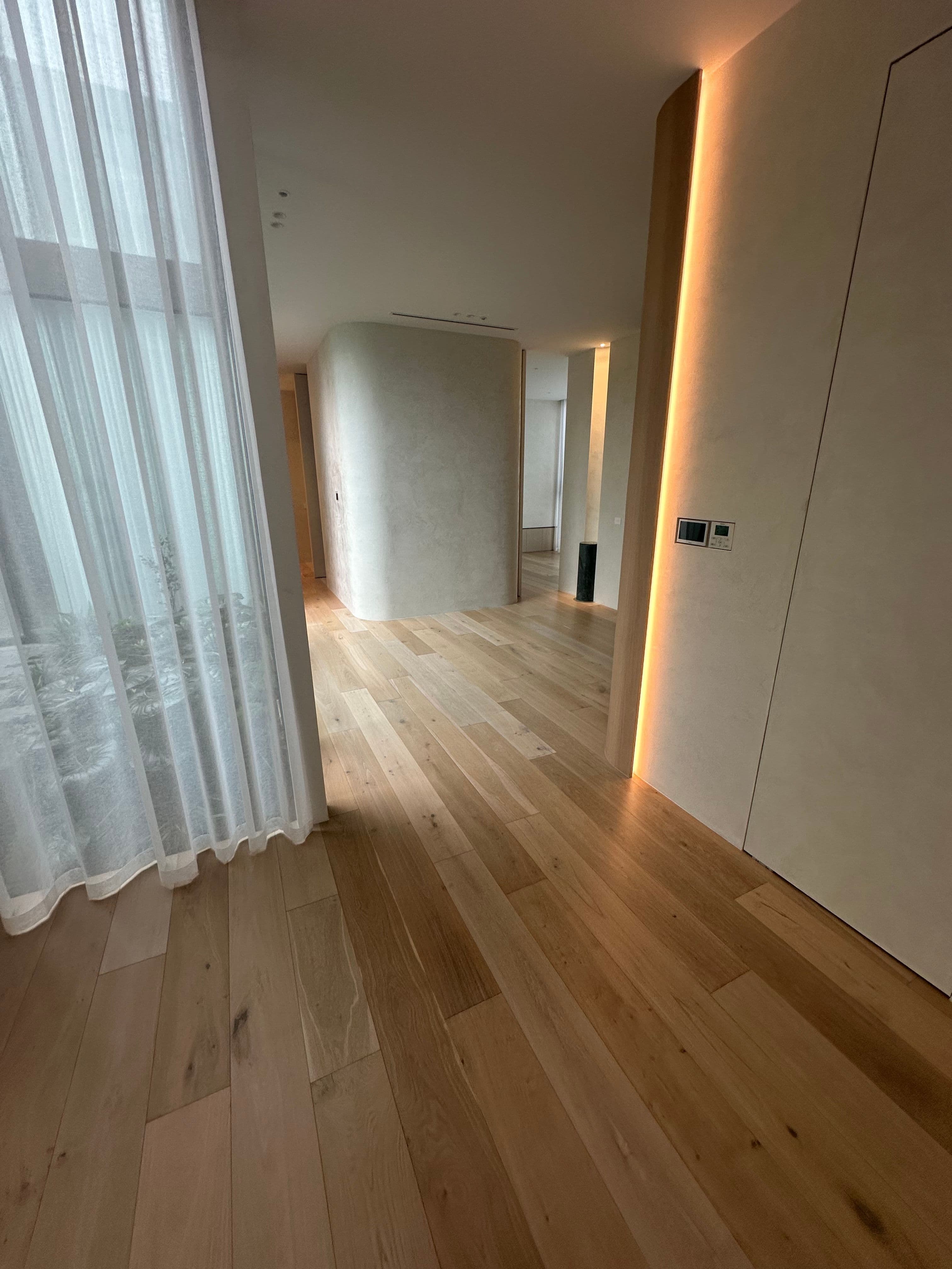 Cashmere oak flooring extending along a softly lit Kew hallway.