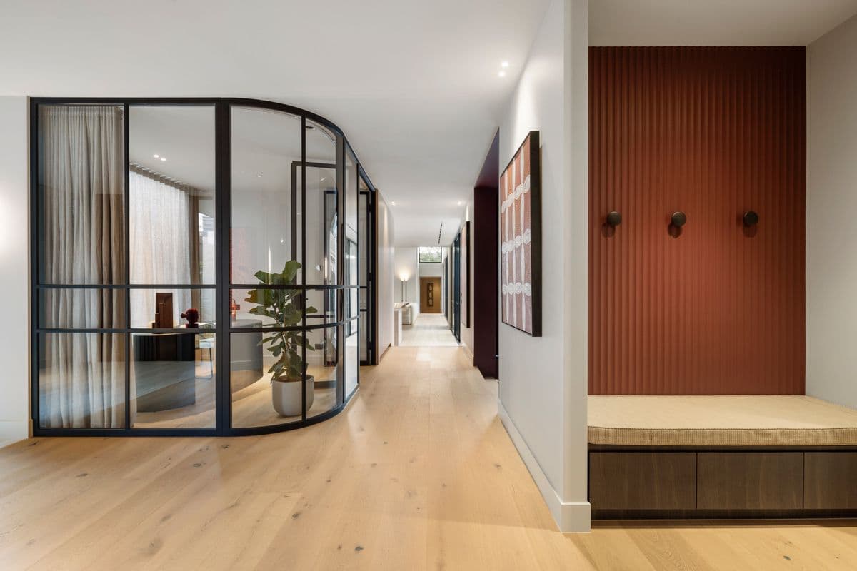 Straight-plank Avoca Bay flooring through a Kew hallway with curved glazing.