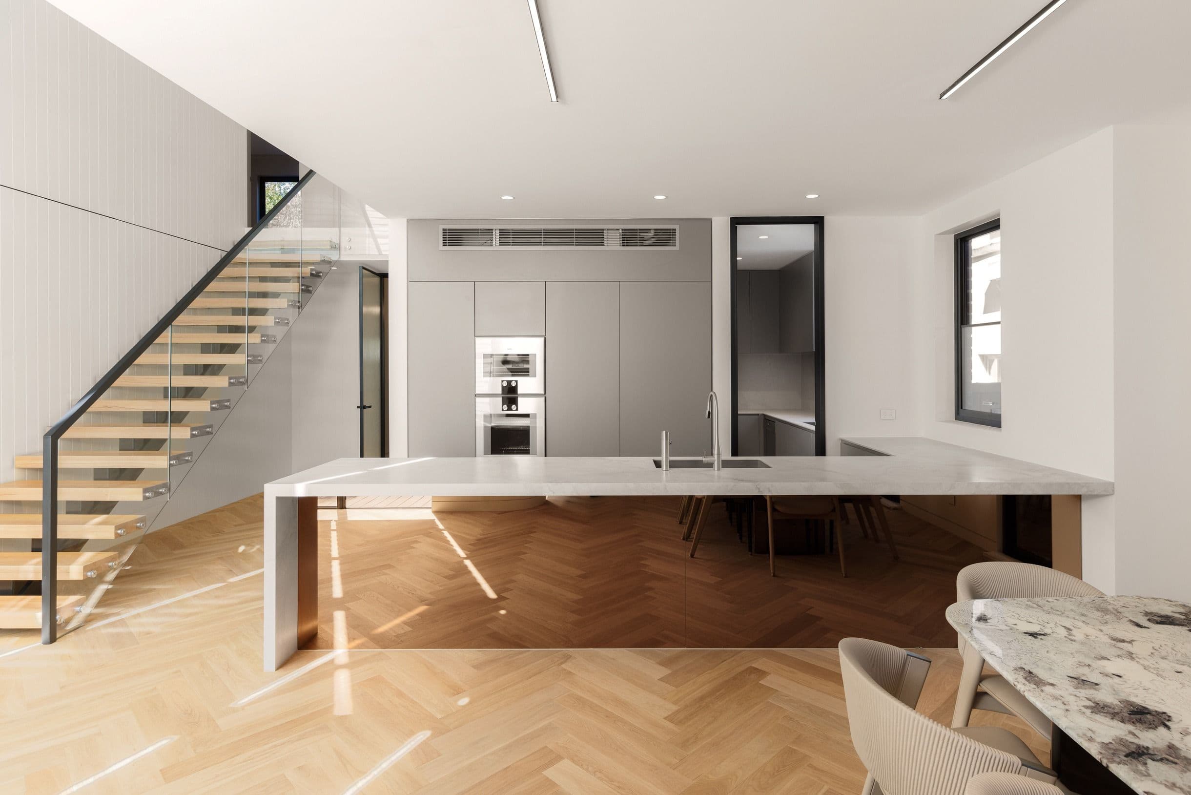Natural Oak herringbone flooring around a kitchen island in Kew.
